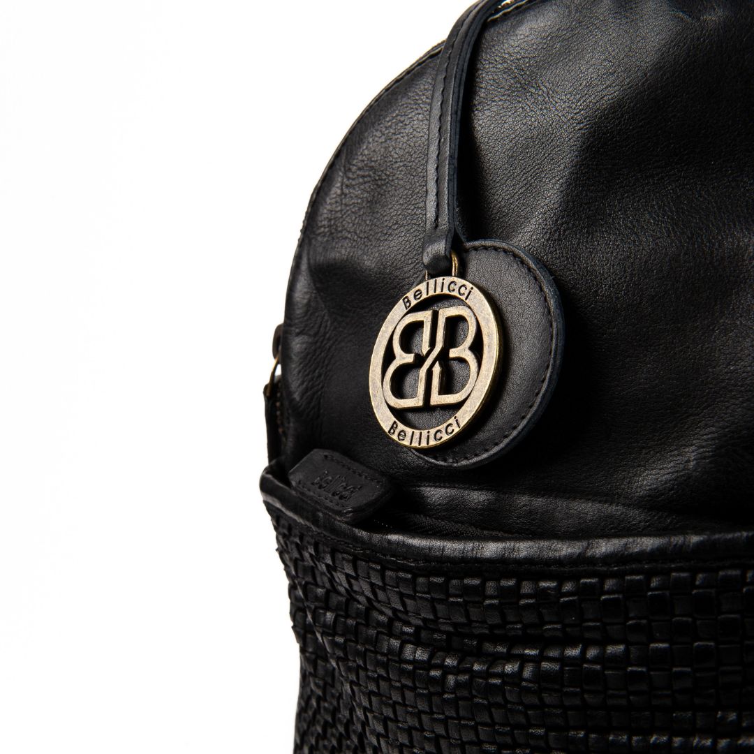 Lederrucksack Eve Bellicci_schwarz_Rucksack für Damen_Slow Fashion_Leder_Lederdeele_Delbrück_Lederwaren_Ostwestfalen_Detail_01 Lederrucksack Eve Bellicci. Leder Rucksack Damen in schwarz. Slow Fashion Rindleder nachhaltig. Lederdeele Delbrück. Lederwaren Ostwestfalen. Detailaufnahme Metall Anhänger Logo